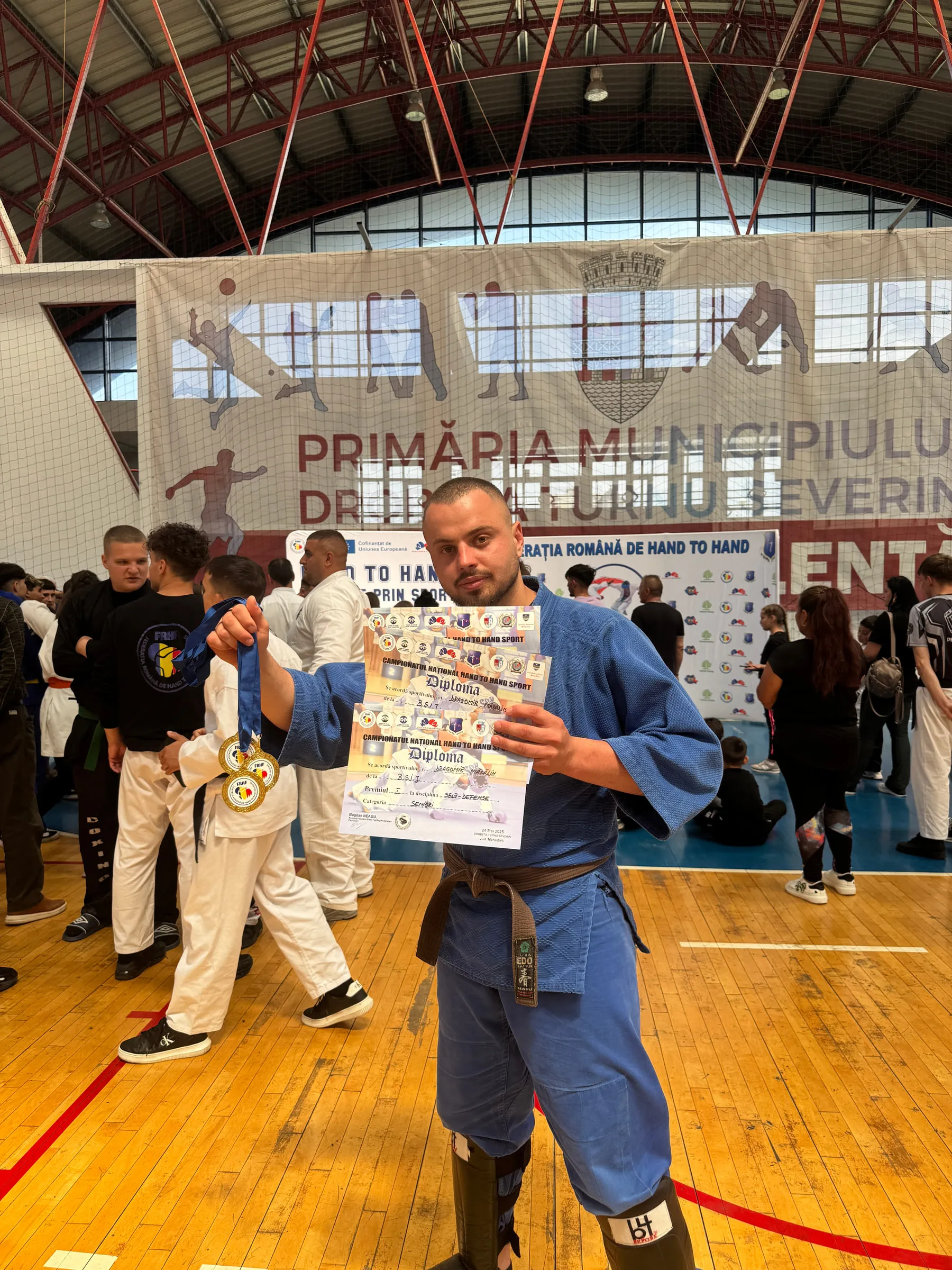 Mădălin Dragomir cu diplomele obținute la o competiție de hand to hand